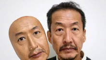 President of Japanese company REAL-f Co. holding a hyper-realistic silicone face mask